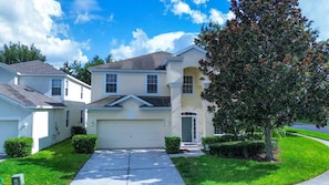 A two-story residential house with a garage, a driveway, and a well-maintained lawn.