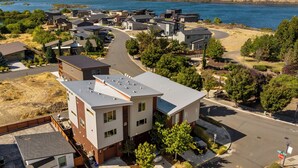 Un quartier résidentiel avec des maisons modernes, une route sinueuse et un lac en arrière-plan.
