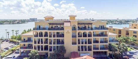 Un hôtel à plusieurs étages, doté de balcons, d’un parking et offrant une vue sur l’eau.