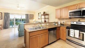 A kitchen with wooden cabinets, stainless steel appliances, and a large island with a sink.