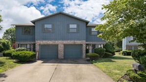 A two-story house with a garage, a driveway, and well-maintained landscaping. - Touch of Class  3-bedroom townhome in Belleville King Bedroom. (Belleville)