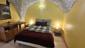 A bedroom with a bed, a wooden dresser, a nightstand, and a wall-mounted lamp. - Serene 2-bedroom chalet in Valjouffrey with stunning mountain views (Valjouffrey)
