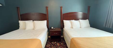 Une chambre d’hôtel avec deux lits simples, une table de chevet et un téléphone.