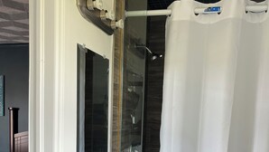 A bathroom with a white sink, mirror, and shower curtain. - East Court Motel (Sarnia)