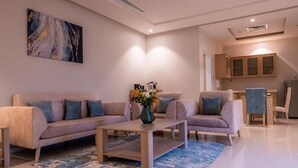 Un salon moderne avec deux canapés, une table basse et un tapis bleu.