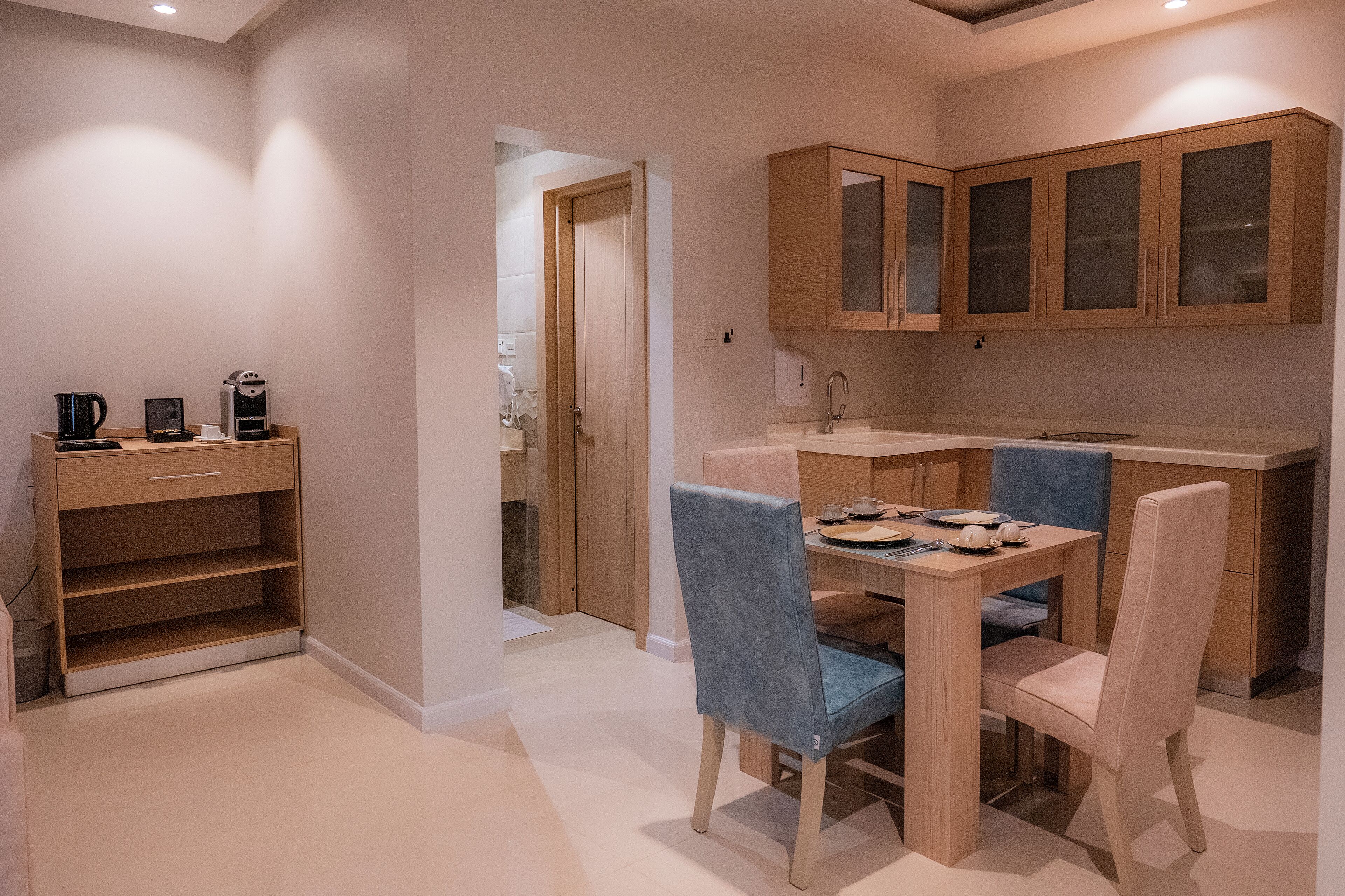 A compact kitchen with wooden cabinets and a dining table with chairs.