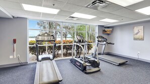 Ein Fitnessstudio mit Laufbändern, Crosstrainern und einem Ergometer.