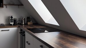 Eine moderne Küche mit Oberlicht, Holz Arbeitsplatte und weißen Schränken.