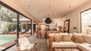 Una sala de estar moderna con un ventanal grande, una piscina y un comedor.