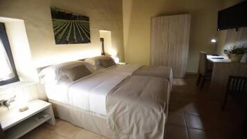 Un dormitorio con una cama, mesitas de noche, un escritorio y una silla.