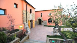 Un patio con muro de piedra, escalones de madera y un pequeño jardín.