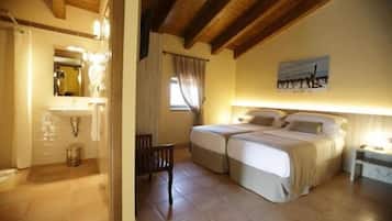 Un dormitorio con dos camas, techo de madera, un cuadro en la pared y una mesita de noche con lámpara.