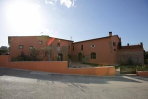 A two-story building with a flat roof and a small balcony. - Hotel Can Panyella (Gelida)