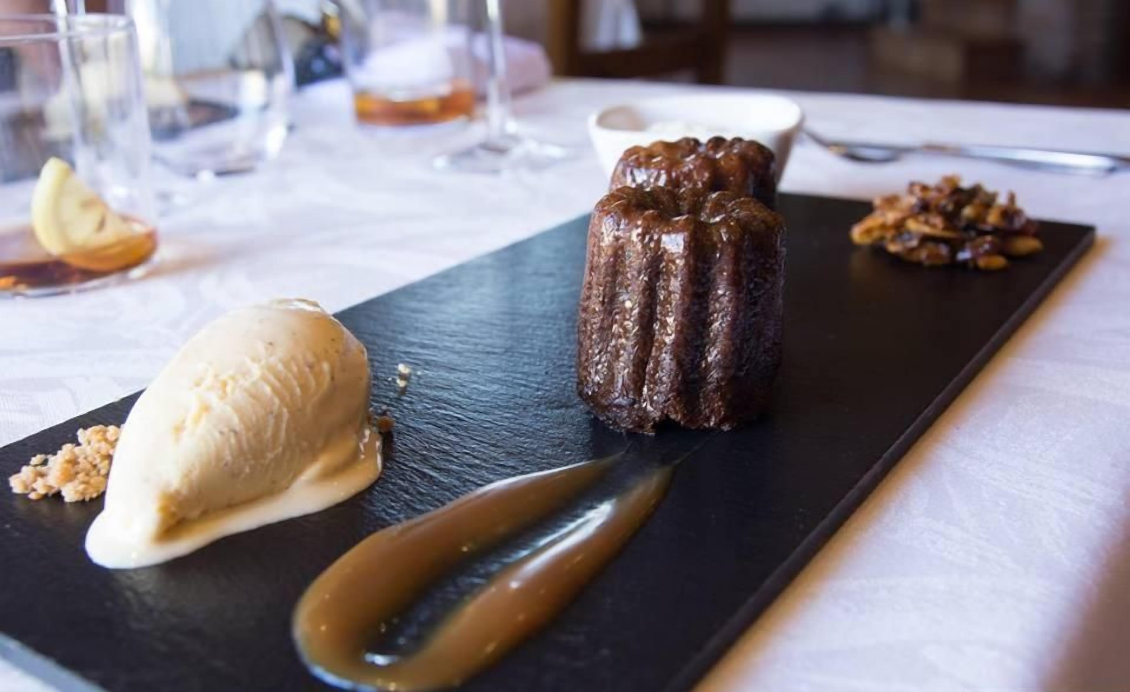 Une assiette de dessert avec un gâteau au chocolat, une boule de glace à la vanille et une sauce au caramel.