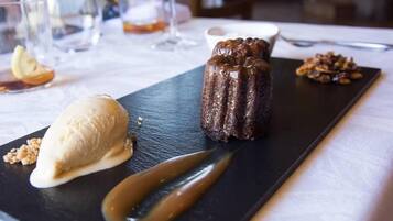 Une assiette de dessert avec un gâteau au chocolat, une boule de glace à la vanille et une sauce au caramel.