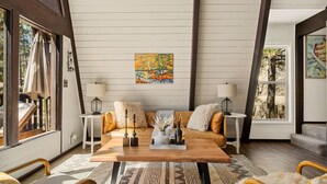 Una sala acogedora con una mesa de centro de madera, un sofá y dos mesitas de noche con lámparas.
