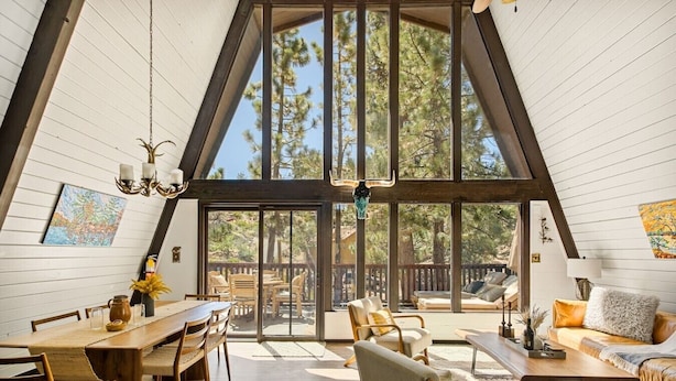 Un loft espacioso con techo alto, ventanas amplias, comedor y una zona de estar acogedora.
