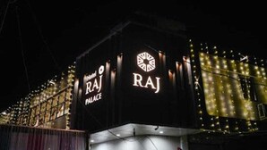 La facciata esterna dell'Hotel Raj Palace con insegne illuminate.