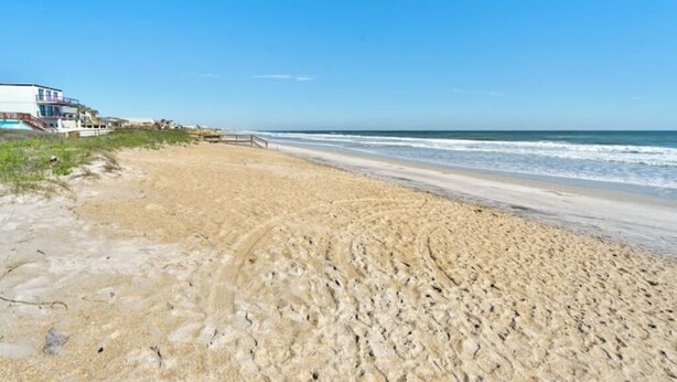 Uma praia com um edifício à esquerda.