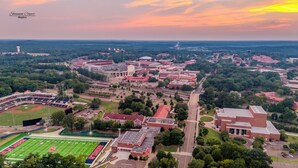 An aerial view of a university campus with multiple buildings, a stadium, and surrounding greenery. - Charming 1-bedroom apartment in Oxford (Oxford)