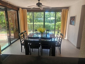Enjoy meals with family and friends in this dining area, featuring a glass-top table and comfortable seating for four.