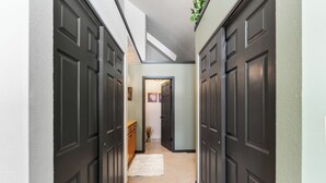 A hallway with dark wooden doors, a white rug, and a plant hanging from the ceiling. - Gac314c2 (Copper Mountain)