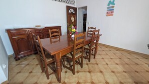 Un coin repas avec une table et des chaises en bois, un buffet et un mur décoratif orné d’enseignes.
