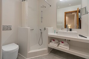 Een douche, handdoeken, zeep, shampoo