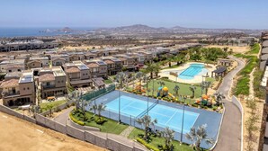 Una zona residenziale con diversi condomini, una piscina e un campo da tennis.