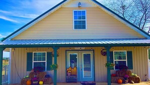 A two-story building with a gabled roof and a covered front porch.