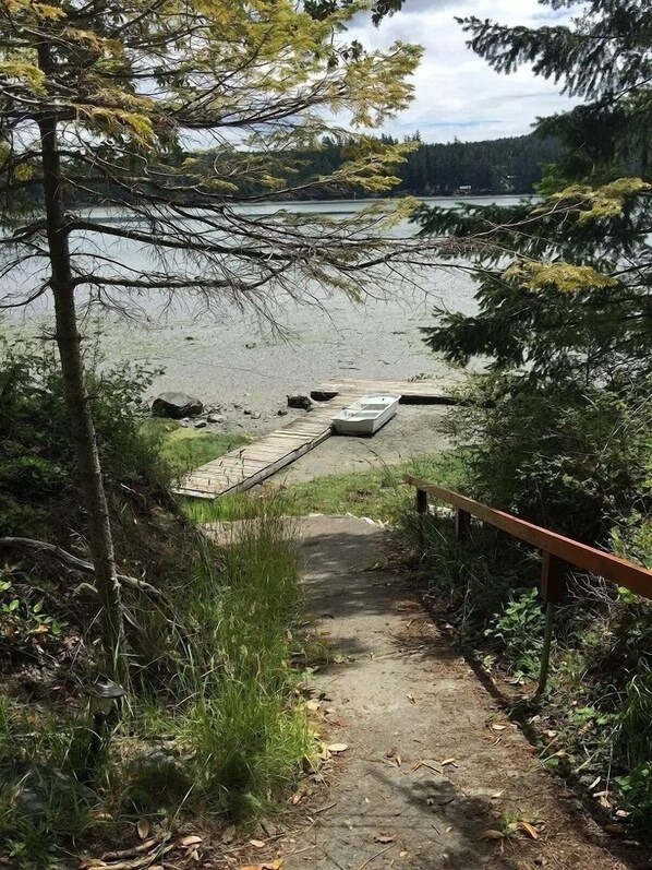 A pathway leading to a dock by a lake, surrounded by trees and vegetation. - Waterfront 3 Bedroom with Kayaks, Dock & Bikes! (Friday Harbor)