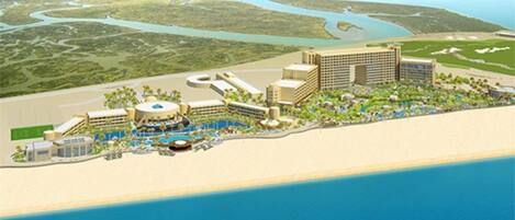 A coastal resort with multiple buildings, a swimming pool, and a beach area.