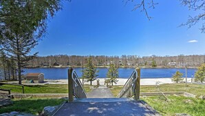 Un sentier qui mène à un lac, d’où l’on peut admirer des maisons et des arbres.