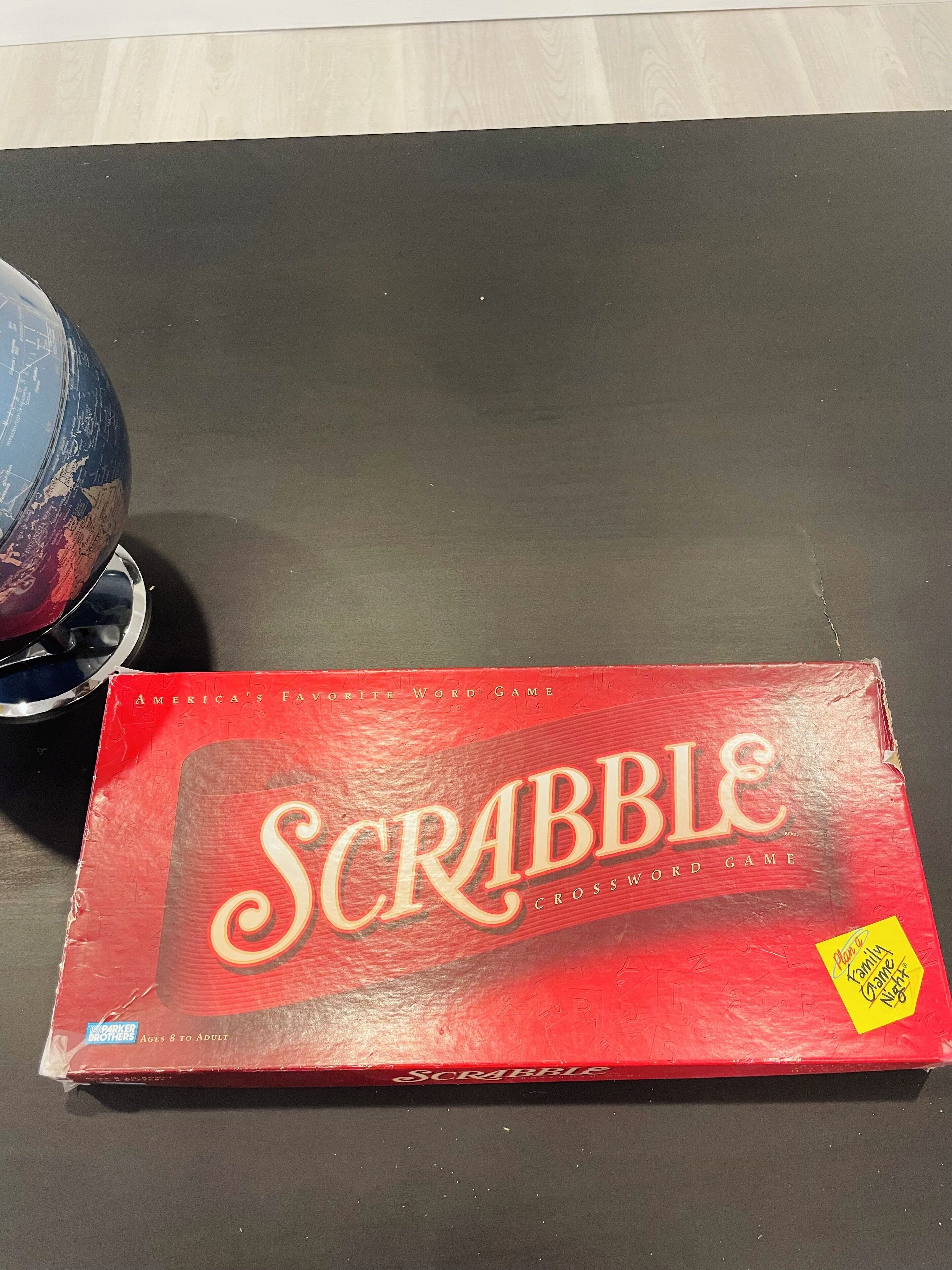 A Scrabble game box on a table.