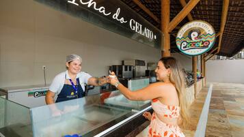 A gelato stand with a sign reading "Icha do GELATO" and a logo for "Piccolo Gelato".