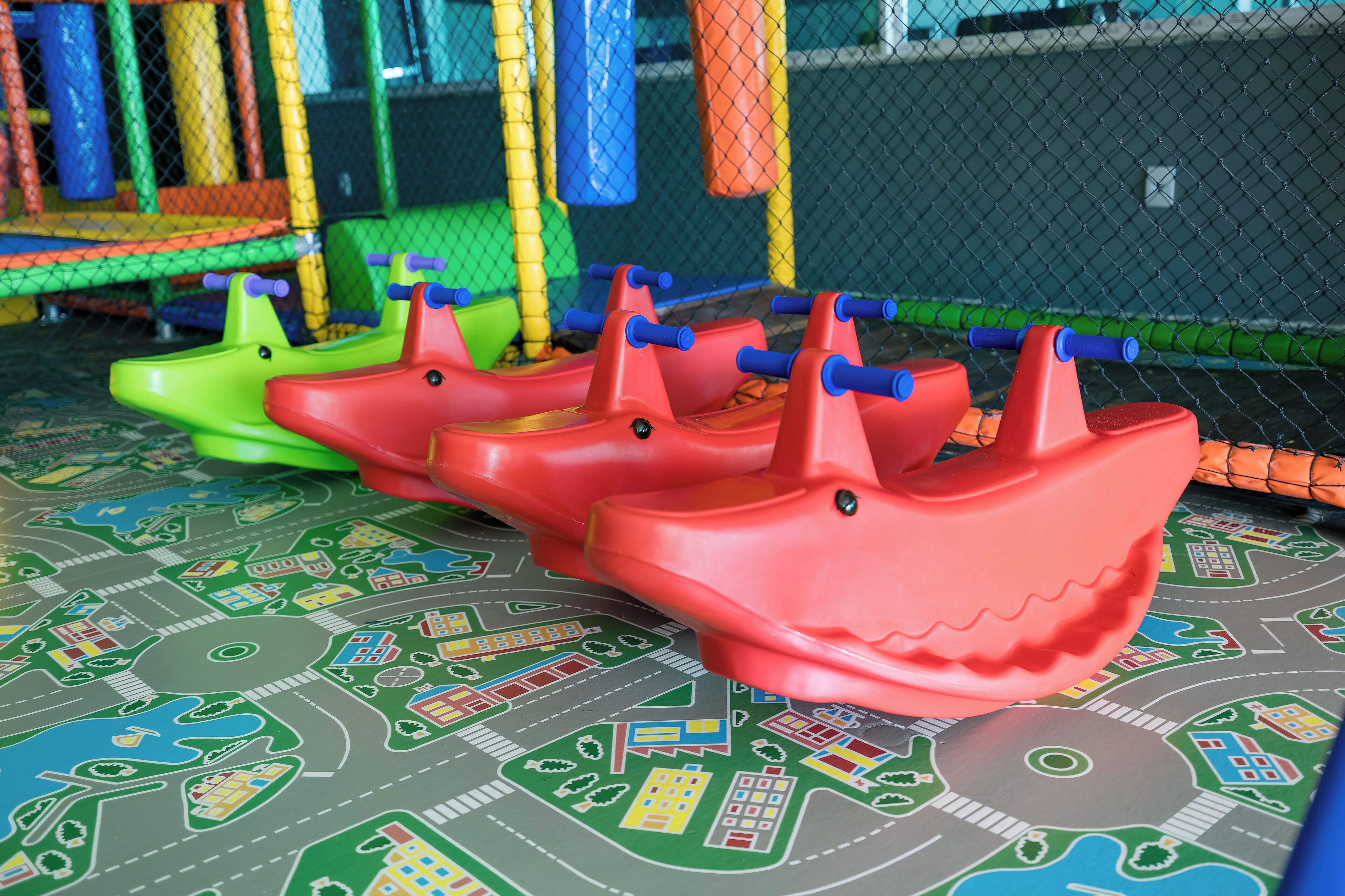 A children's play area with colorful plastic boats and a play mat with cityscape designs.