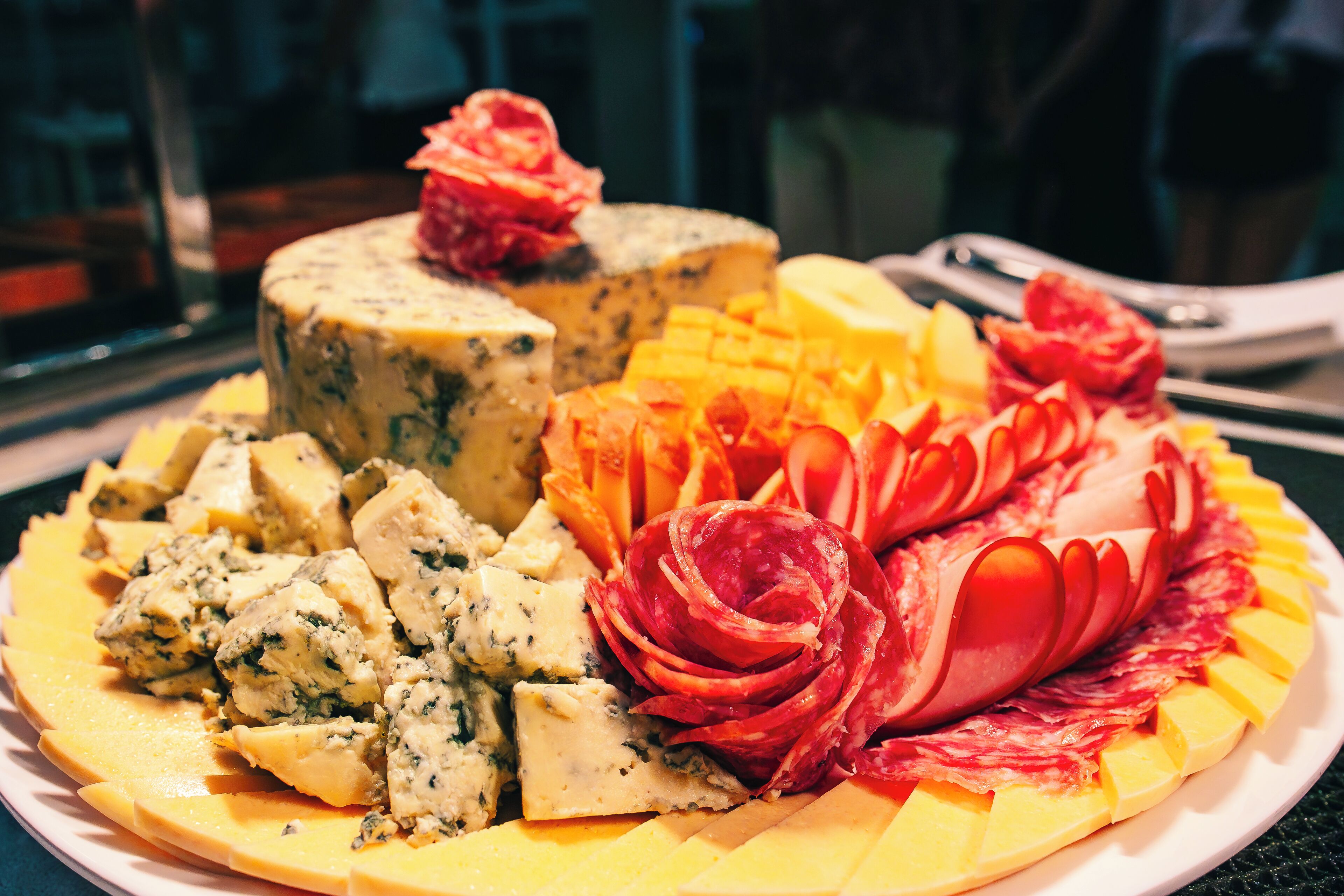 Un plato con una variedad de quesos y embutidos.