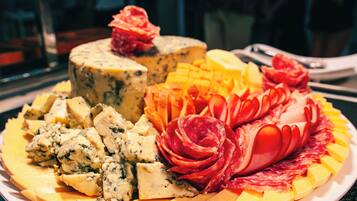 Un plato con una variedad de quesos y embutidos.