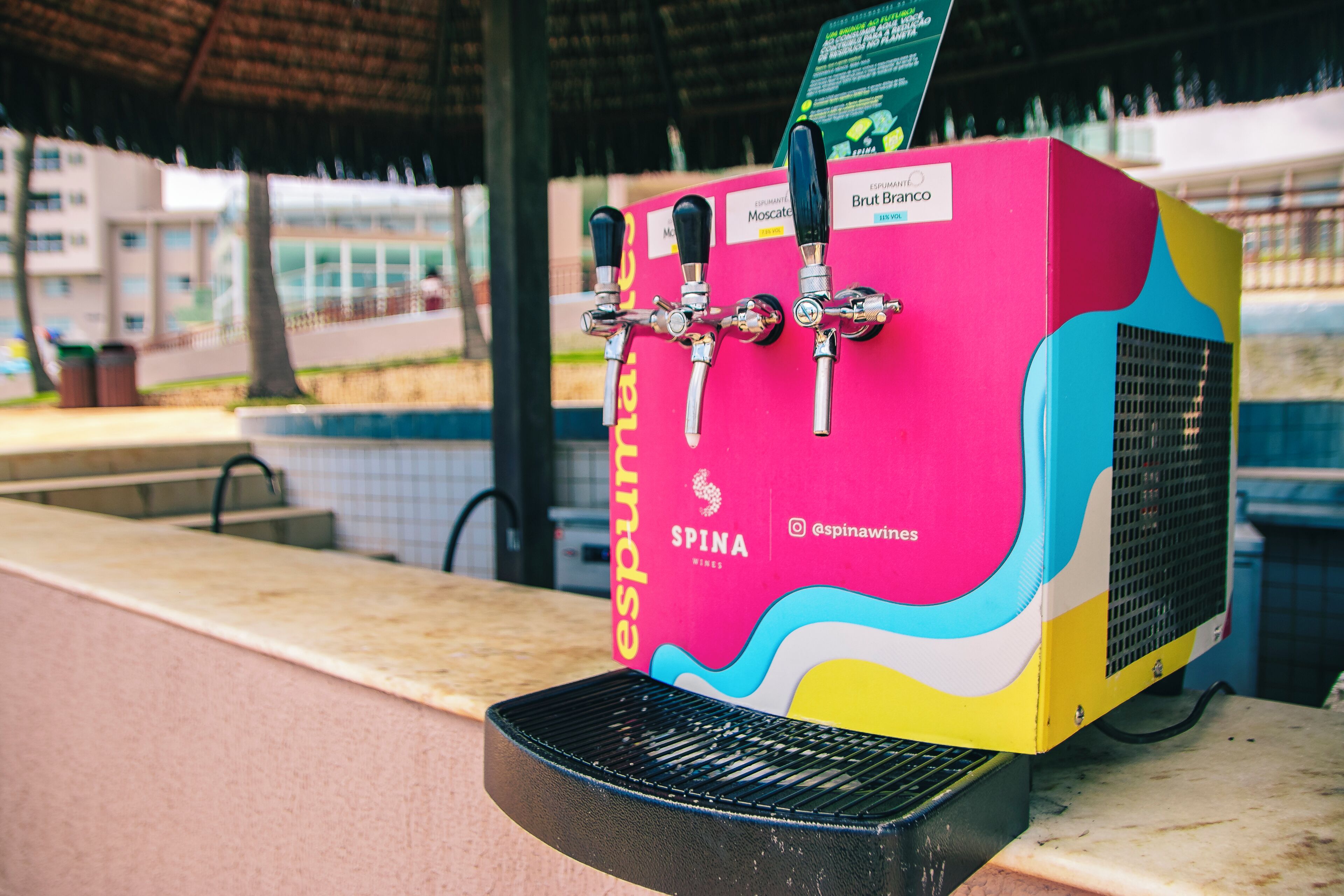 A colorful beverage dispenser with multiple taps, a spina logo, and a grill below it.
