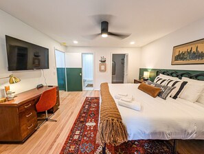Une chambre d’hôtel moderne équipée d’un lit, d’un bureau, d’une chaise et d’un téléviseur.