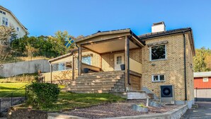 A two-story house with a wooden deck, a front porch, and a flag. - 4 bedroom lovely home in Sommen (Sommen)