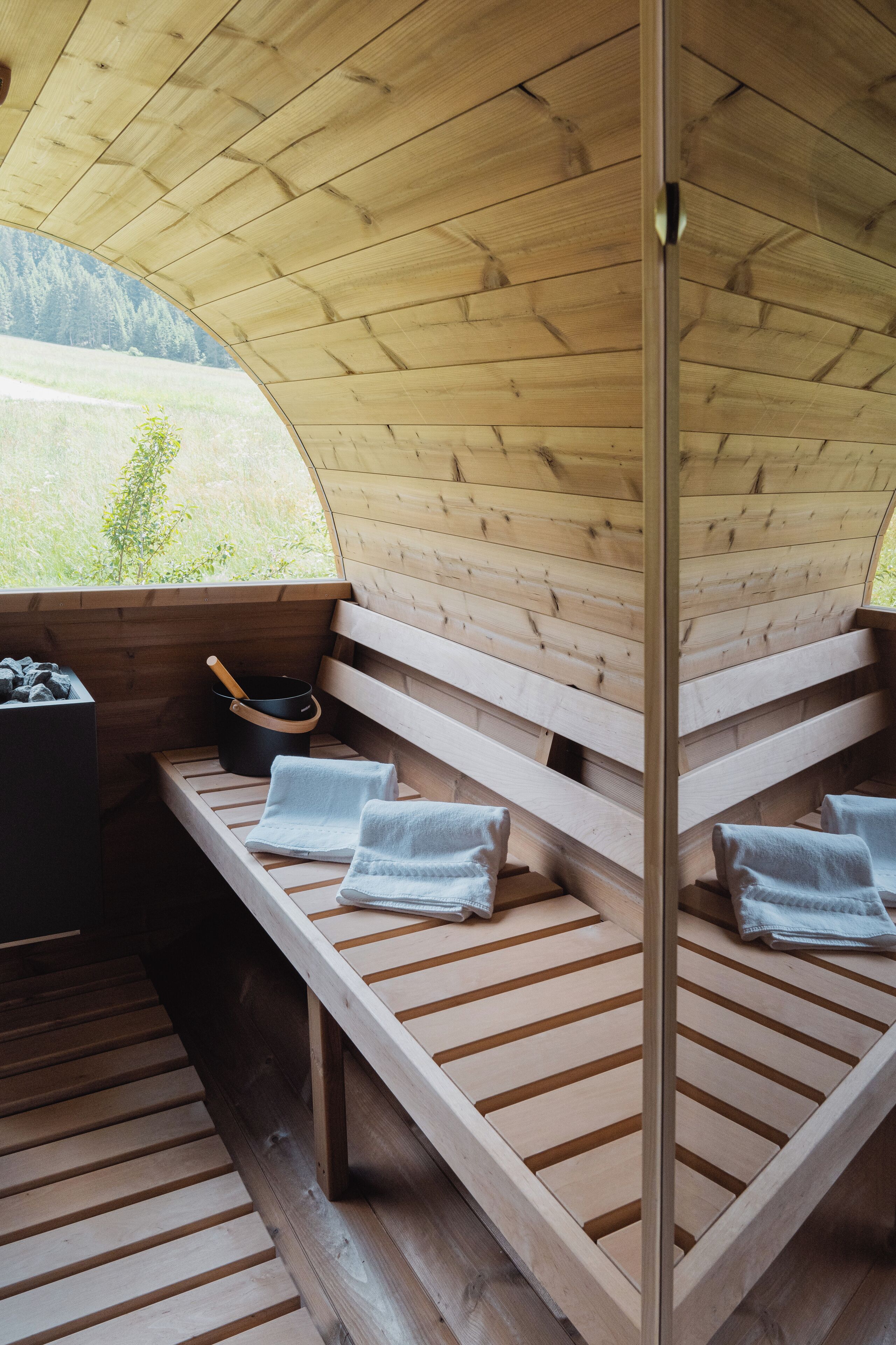 A wooden cabin with a bench and a pot on the bench.