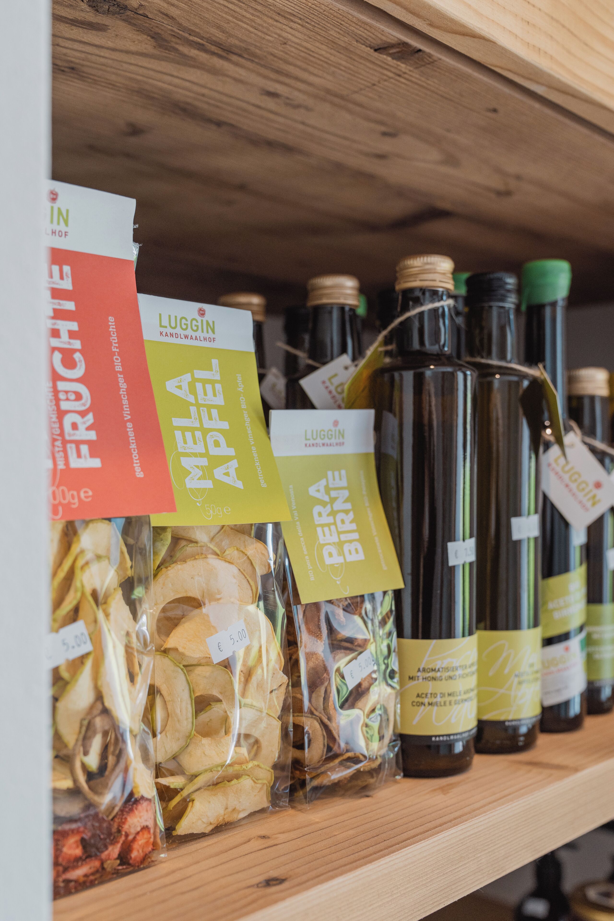 Una estantería con frutas secas y botellas de vino.