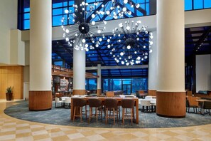 A spacious lobby with a central seating area, large windows, and modern lighting fixtures. - 3 Connecting Suites at a 4⭐️ Hotel (Orlando)