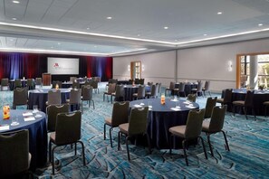 A conference room with round tables, chairs, and a presentation screen. - 3 Connecting Suites at a 4⭐️ Hotel (Orlando)