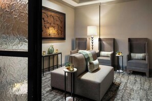 A modern hotel room with a sofa, armchairs, a lamp, and a painting on the wall. - 3 Connecting Suites at a 4⭐️ Hotel (Orlando)