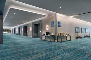 A hotel lobby with a blue carpet, a reception desk, and directional signs. - 3 Connecting Suites at a 4⭐️ Hotel (Orlando)