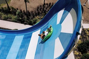 A water slide with a person and an inflatable tube at the bottom. - 3 Connecting Suites at a 4⭐️ Hotel (Orlando)