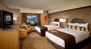 Une chambre d’hôtel avec deux lits, une télévision, un bureau et une vue sur la ville.