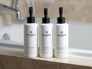 Three bottles of Balmain Paris body wash, shampoo, and conditioner on a bathroom counter. - 2 Connecting Suites at a 4.5⭐️ Hotel (Chicago)